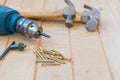 Screw,hammer and electric drill on wood