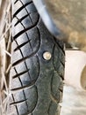 Screw nail puncturing motorcycle tire. Close up view at rear wheel. vertical Royalty Free Stock Photo