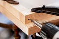A screw is screwed into wood with a cordless screwdriver