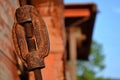 A thread - rusty, aged and dirty metallic part with a building in the background.