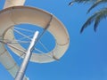 Screw water slide and palm tree leaves from below at water park summer holiday Royalty Free Stock Photo