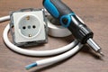 Screwdriver, cable, insulating tape and power socket on wooden table, closeup Royalty Free Stock Photo