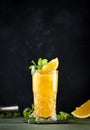 Screwdriver, classic alcoholic cocktail with vodka, orange juice and ice, garnished with fruit slice and mint. Dark background,