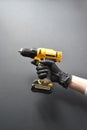 screwdriver in a female hand in a glove on a black background Royalty Free Stock Photo