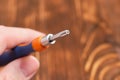 Screwdriver with interchangeable cross head in hands on a wooden background Royalty Free Stock Photo