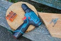 One big screwdriver and a set of bits in orange next to a pile of screws on brown wooden table boards Royalty Free Stock Photo