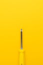 Screwdriver on yellow background Royalty Free Stock Photo