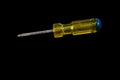 Screwdriver with a yellow and blue handle isolated on a black background Royalty Free Stock Photo