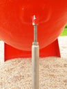 Screwed pole point of red plastic construction. Detail of decreased iron screws and metal tube in outdoor red equipment Royalty Free Stock Photo