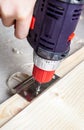 Close up of a carpenter screwed a hinge on a wooden plank Royalty Free Stock Photo