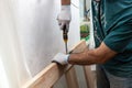 Close up of a carpenter screwed a hinge on a wooden plank Royalty Free Stock Photo