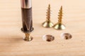 Screwing metal screws into chipboard for furniture construction. Small carpentry work in the home workshop