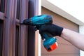 Screwing roofing screws into a metal picket fence by using cordless electric screwdriver. Royalty Free Stock Photo