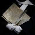 The scribe holds an old book