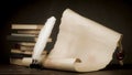 Scroll of parchment and inkwell with a pen on the background of the stack of books Royalty Free Stock Photo