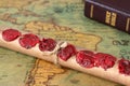 Scroll with seven seals on ancient world map with closed holy bible book, a close-up