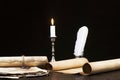 Scrolls of parchment and old papers on the background of a lit candle and inkwell pen Royalty Free Stock Photo