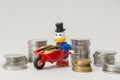 Scrooge McDuck carrying coins on a wheelbarrow on white background Royalty Free Stock Photo