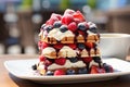 Scrumptious viennese waffles with fresh berries and syrup served on an outdoor cafe table Royalty Free Stock Photo