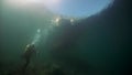 Scuba diver cameramen shoots underwater video of boat on Baikal.