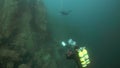 Scuba diver cameramen swimming deep underwater in Lake Baikal.