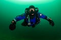 SCUBA diver in a drysuit and rebreather underwater in a cold, dark, murky quarry Royalty Free Stock Photo