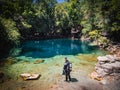 Scuba diver entering the shallow clear blue spring waters in lush forest, Royal Springs, County Park, Florida