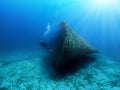 A Scuba diver explores a sunken shipwreck in the mediterranean sea Royalty Free Stock Photo