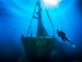 A scuba diver in front of a sunken shipwreck