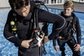 A scuba diver is getting his gear ready by inserting a weight pocket Royalty Free Stock Photo