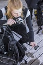 Scuba diver kitting up and checking her gear