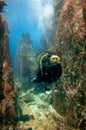 Scuba diver in a rocky canyon reef. Royalty Free Stock Photo