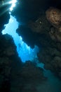 Scuba diver silhouette outside an underwater cave.