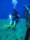 A Scuba Diver sitting on the deck of a sunken tankers