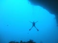 Scuba diver at underwater cave exit