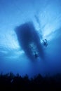 Scuba divers ascending to a boat Royalty Free Stock Photo