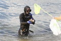 Divers during environmental cleaning beach day removing plastic