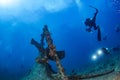 Scuba divers explores propeller of sunken shipwreck Royalty Free Stock Photo