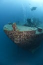 Scuba divers exploring the bow of a shipwreck. Re Royalty Free Stock Photo