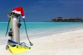 Scuba diving gear with a christmas hat on a beach