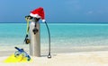 Scuba diving gear on tropical beach with a christmas hat