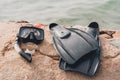 Scuba diving mask and fins on sand near the water Royalty Free Stock Photo