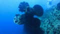 Scuba diving at ship wreck propeller in blue deep water, man diver on the background