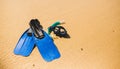 Scuba mask with flippers on the beach sand. Blue fins on the sandy beach Royalty Free Stock Photo