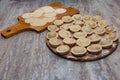 Sculpt pierogy and pelmeni concept. Include rustic cutting board, making pierogies on a rustic wooden table. dumplings