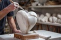 sculptor chiseling a marble heart in a studio