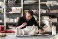 The sculptor conducts restoration work in a plaster workshop. Restoration of the gypsum head of Apollo