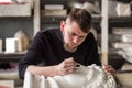 The sculptor conducts restoration work in a plaster workshop. Restoration of the gypsum head of Apollo