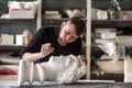 The sculptor conducts restoration work in a plaster workshop. Restoration of the gypsum head of Apollo