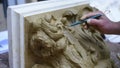 Sculptor create clay model of a Corinthian capitel with scrolls and unfurled acanthus leaves in restoration workshop